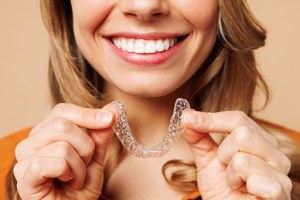woman holding clear braces